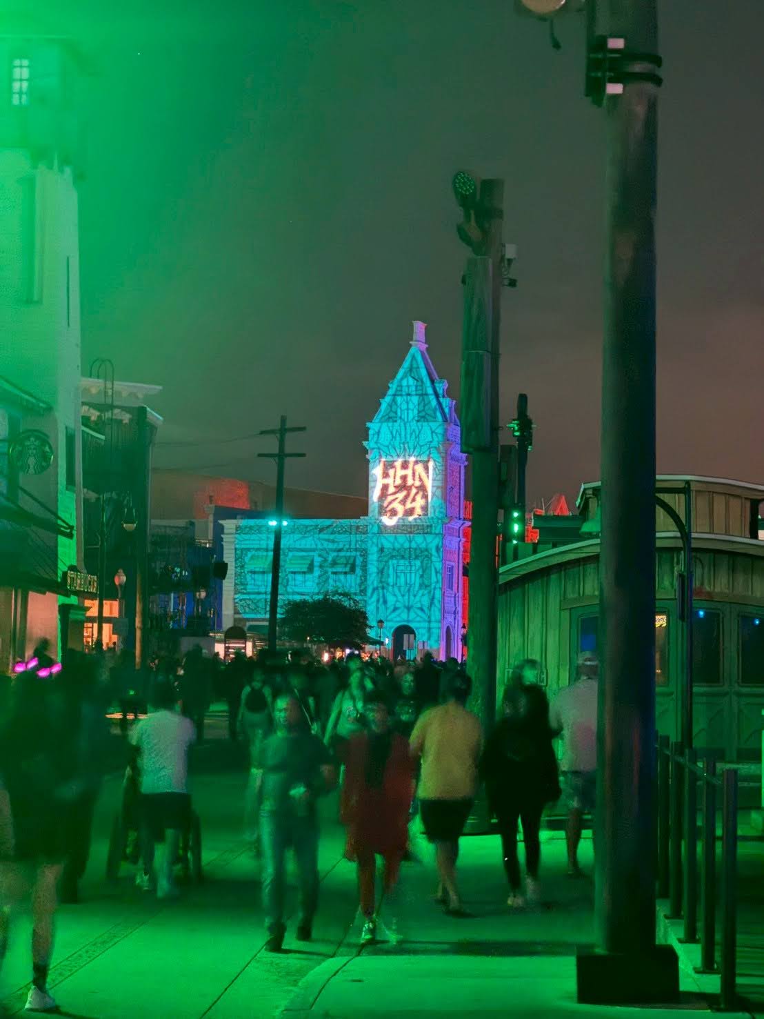 HHN34の夜のパーク全景。緑のスモークと幻想的な照明